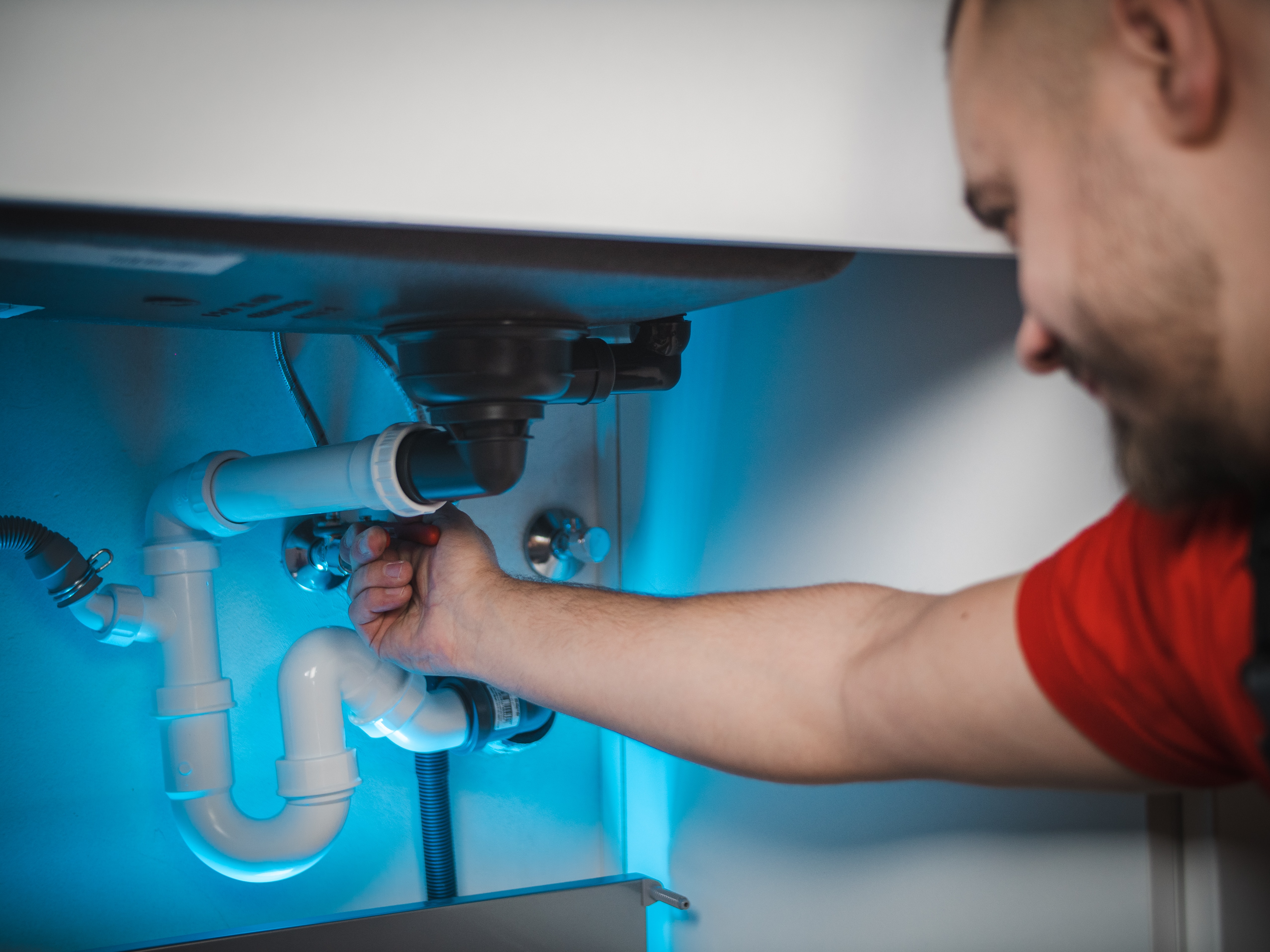 Professional plumber working on pipe installation